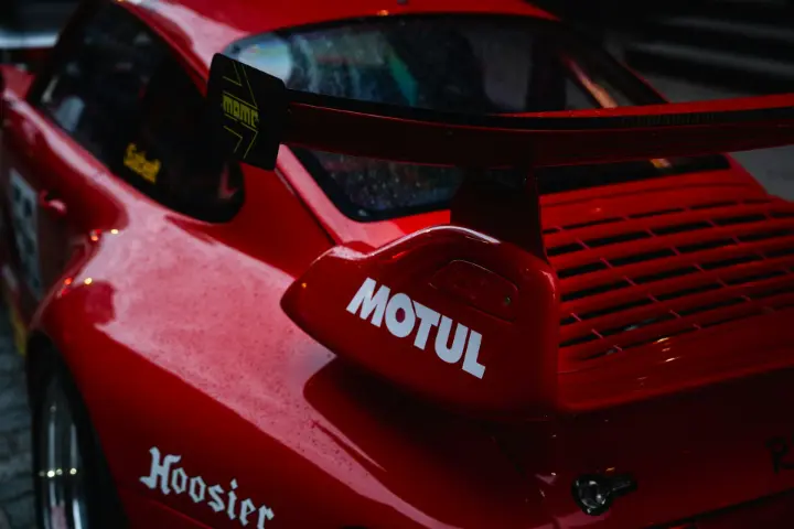 A red race car's spoiler is shown.